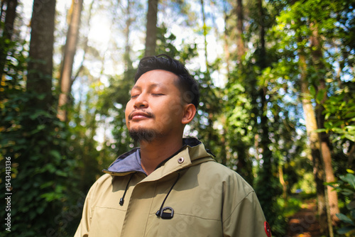 Man Relaxing in Forest With Sunlight Passing Through Trees