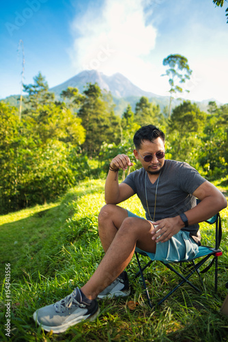 Man Relaxing on a Chair with Scenic Merapi Mountain Landscape
