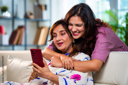 Photography Senior mom and young daughter using smartphone happily for online shopping in li