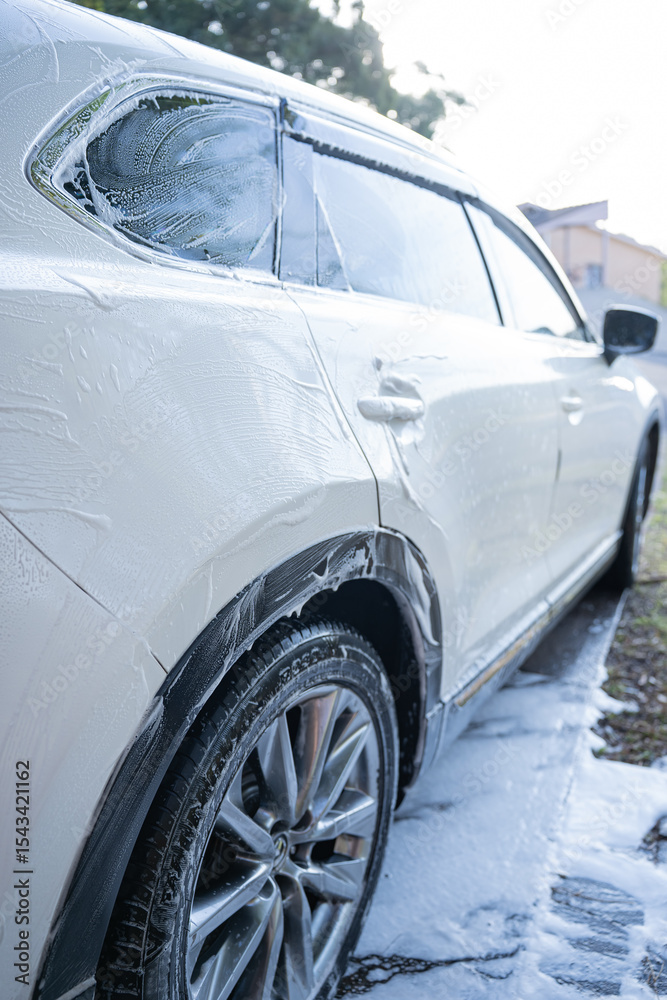 Fototapeta premium washing a dirty car and wheels with water and a pressure washer