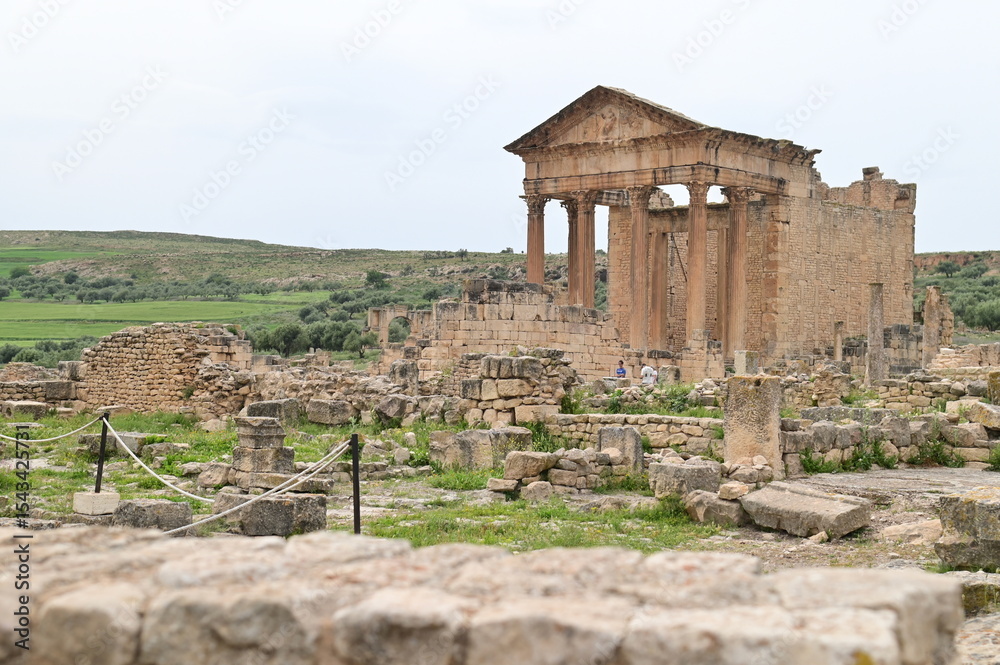 Fototapeta premium Temple of Saturn with a Panoramic View of the Ancient City of Dougga and Surrounding Hills in Tunisia