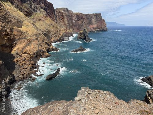 Picturesque view of small bay of Madeira Island, high rocky coastline, and ocean waves.