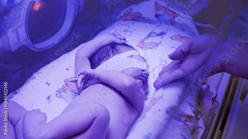 A newborn baby undergoing neonatal phototherapy treatment in a clinic, exposed to ultraviolet light.
