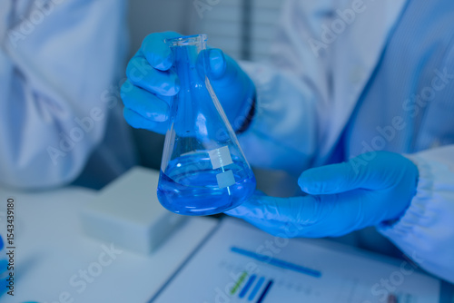 when in a lab, scientists wear lab coats, rubber gloves, and safety goggles, two chemists are testing chemicals in a liquid state, chemists working in a laboratory