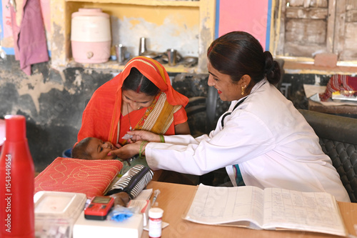 Canvas Print Indian health workers giving polio vaccine to baby