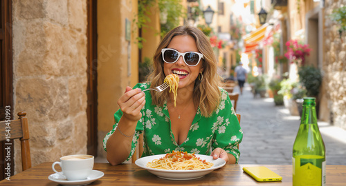 Fototapeta Naklejka Na Ścianę i Meble -  Woman eating spaghetti at an outdoor cafe in italy
