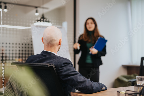 Photos Two colleagues in a formal office environment having a discussion during a meeting