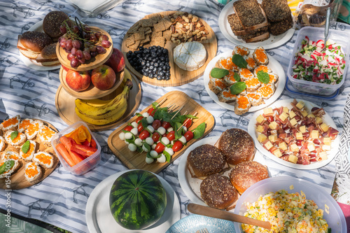 Summer Picnic Food Spread with fresh fruit, cheese platter, bread, and various appetizers arranged