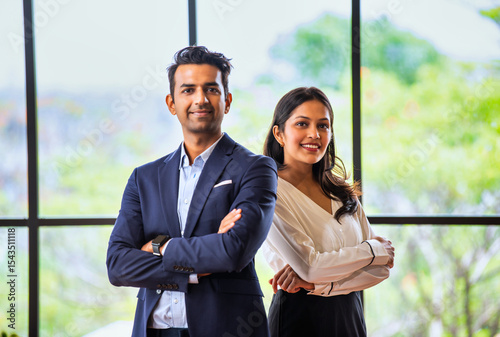 Posing with success and smiling confidently, Indian business professionals stand in office together