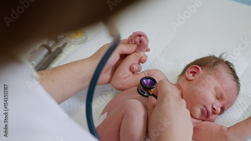 A doctor examines a newborn baby in a clinic setting, potentially for neonatal care, using medical instruments.