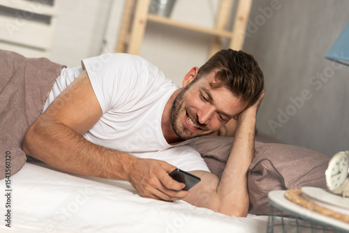 Smiling young man flirting over the phone