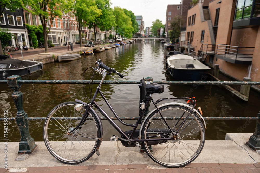 Obraz premium Classic Dutch bicycle parked on a bridge over a canal in Amsterdam