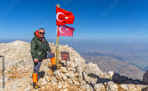 Hiker is posing at the summit of Kızlar Sivrisi Mountain (3070 m.) at Elmalı, Antalya, Turkey