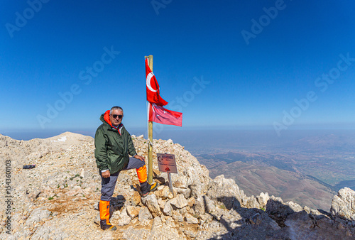 Hiker is posing at the summit of Kızlar Sivrisi Mountain (3070 m.) at Elmalı, Antalya, Turkey