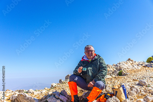 Hiker is posing at the summit of Kızlar Sivrisi Mountain (3070 m.) at Elmalı, Antalya, Turkey