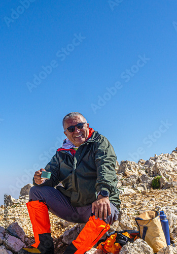 Hiker is posing at the summit of Kızlar Sivrisi Mountain (3070 m.) at Elmalı, Antalya, Turkey