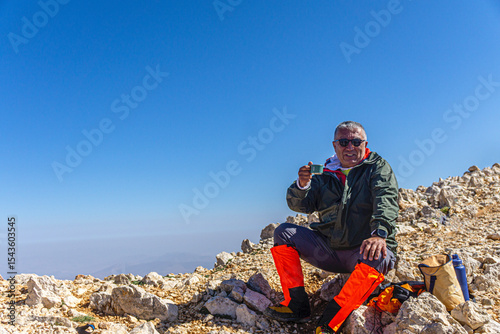 Hiker is posing at the summit of Kızlar Sivrisi Mountain (3070 m.) at Elmalı, Antalya, Turkey