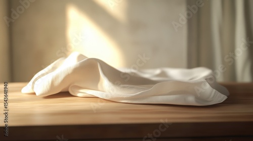 Soft White Fabric Draped on Wooden Table  Sunlight