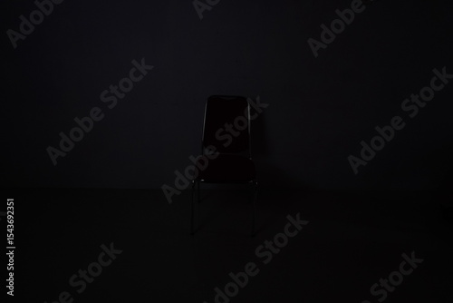 A chair in a dark room. The chair is often symbolized as a throne that is much fought over.