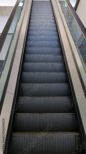 Moving up escalator in a large hypermarket, escalator stairs to the upper level