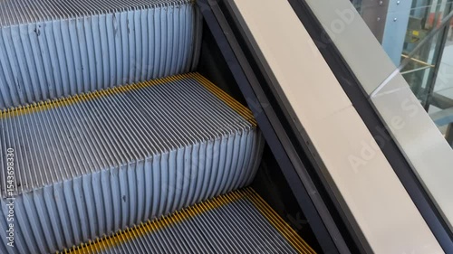 Ascent on an escalator in a large shopping center, escalator steps close-up
