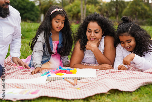 Happy indian family having playful time in nature park - Asian culture and childhood concept