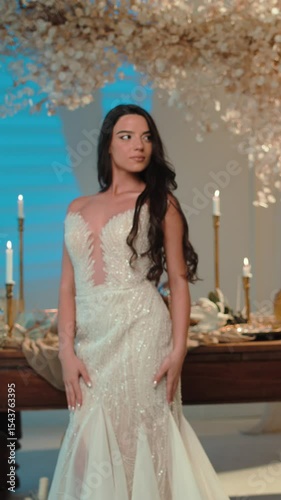 Elegant bride in intricately detailed wedding gown posing indoors