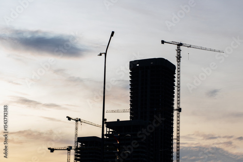 A busy construction site with cranes and a building being built