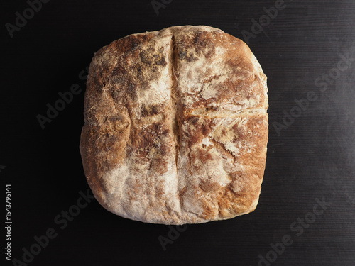 Freshly baked artisan bread on wooden surface.
