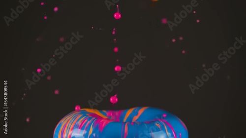 Vibrant paint splash with blue and pink colors creating dynamic patterns against a dark background