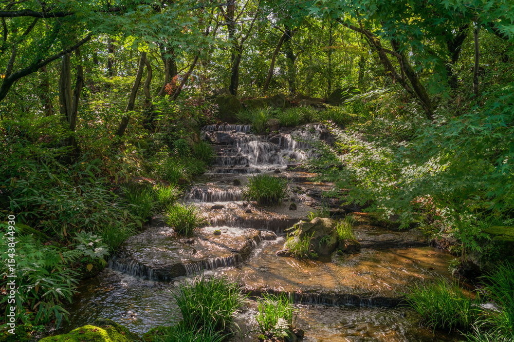 Obraz premium Cascade of waterfalls in Oyashiki Park of the Koko-en Garden on a sunny autumn day, Himeji, Hyogo Prefecture, Japan