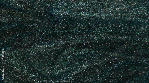 Macro background of a dark shimmer texture featuring emerald green tones and fine glitter. Stylish abstract surface for creative use.