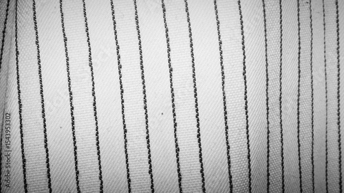 Extreme close-up of parallel dark stitching on white woven fabric. Clean, minimalist textile pattern. Great for textile design, craft blogs, and fashion industry backgrounds