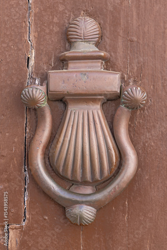 Arcos de la Frontera, Seville Province, Andalusia, Spain. A copper knocker on an old wooden door. photo