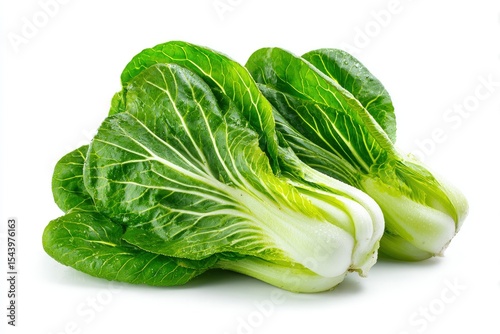 Two bok choy heads lay closely together featuring large green leaves and thick white stems