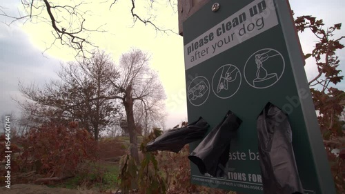 Grabbing a dog poop bag from dispenser in park 4k
