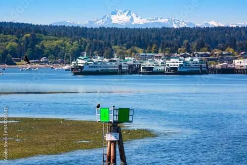 Fotografie Former and current Puget Sound ferries docked in Eagle Harbor in Winslow, Bainbridge Island with views of snow capped Olympic Mountains, Washington State, USA