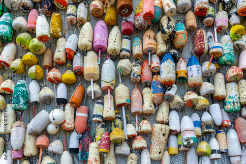 Colorful fishing buoys on wall with net