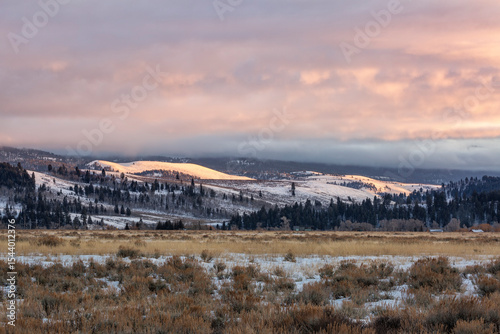 USA, Wyoming, Grand Teton National Park, Jackson. Sunset lights up snowy hill...