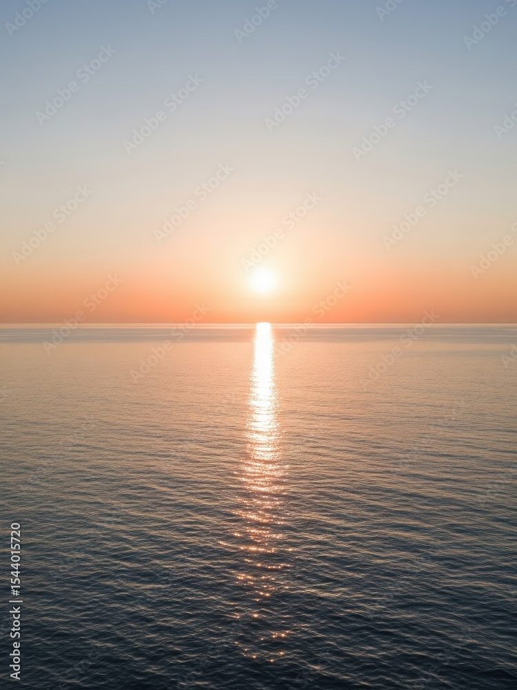 Naklejka premium Open ocean during golden hour, soft gradient sky from peach to blue, sun near the center casting long reflection, no land in sight, peaceful and minimal