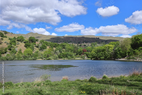 Panorama of Rydal Water surrounded by green hills and trees under a partly cloudy blue sky in the Lake District, England, United Kingdom. photo
