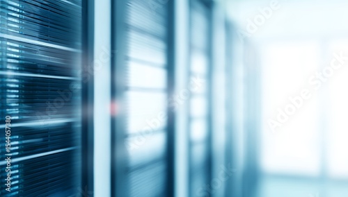 Blurred aisle of server racks in a modern data center with bright light, representing cloud computing and network infrastructure.