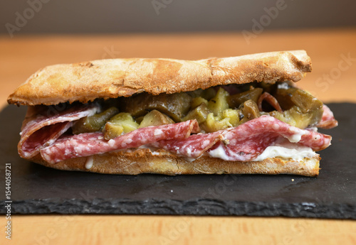 Ciabatta sandwich with salami and pickled cucumbers