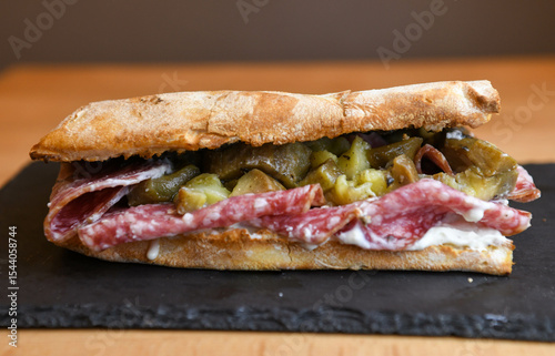 Ciabatta sandwich with salami and pickled cucumbers