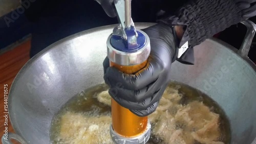 cooking or making traditional Indonesian coconut root cake by frying it in a pan