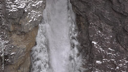Water rushing through winter cave with frozen crystals slow motion
