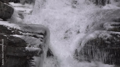 Rolling water down frozen rocks slow motion
