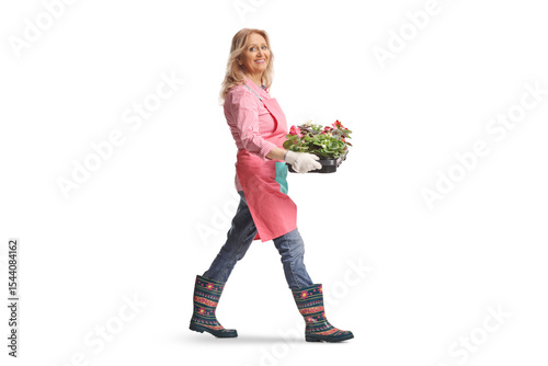 Woman gardener carrying a tray with flowers
