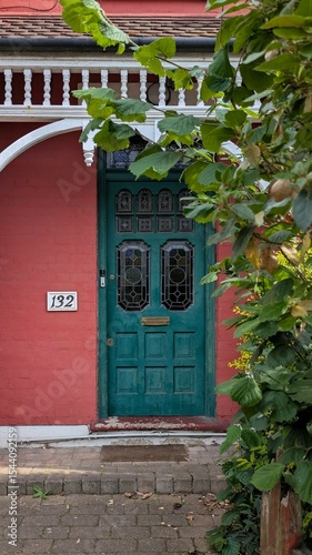 Old victorian wooden door with stained glass in a red brick wall, London