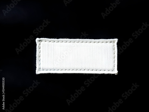Blank white fabric label with stitched border on black background. Ideal for clothing tag mockups or branding purposes. Generative AI